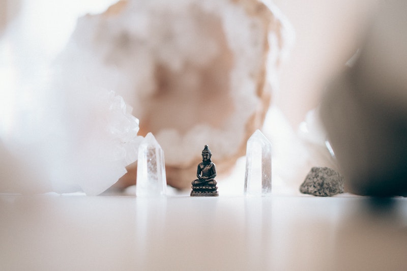 image of small clear crystals and a small buddha figure